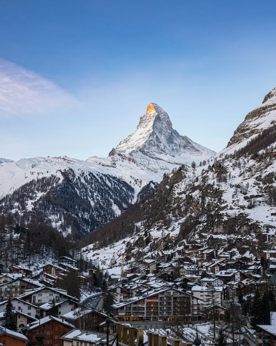Snow-laden timber chalet exterior in Zermatt at first light.
